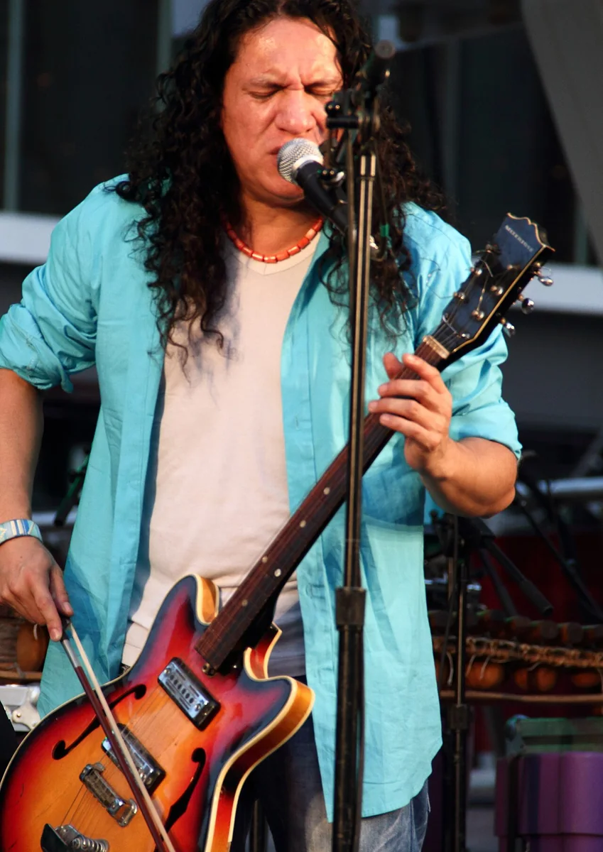Illustrative photograph of an electric guitar being played with a violin bow on stage