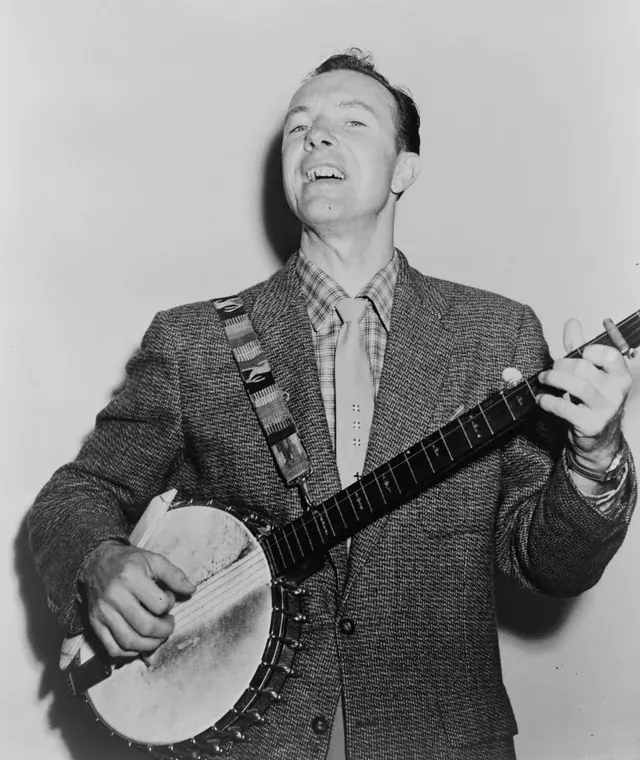 Pete Seeger playing banjo in a documentary press photograph