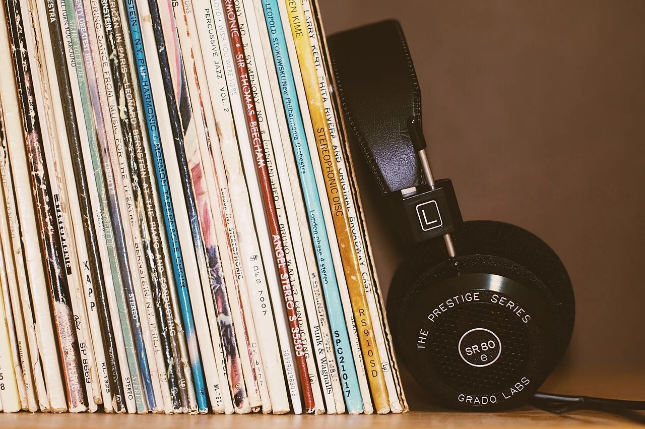 Headphones resting against a shelf of vinyl records