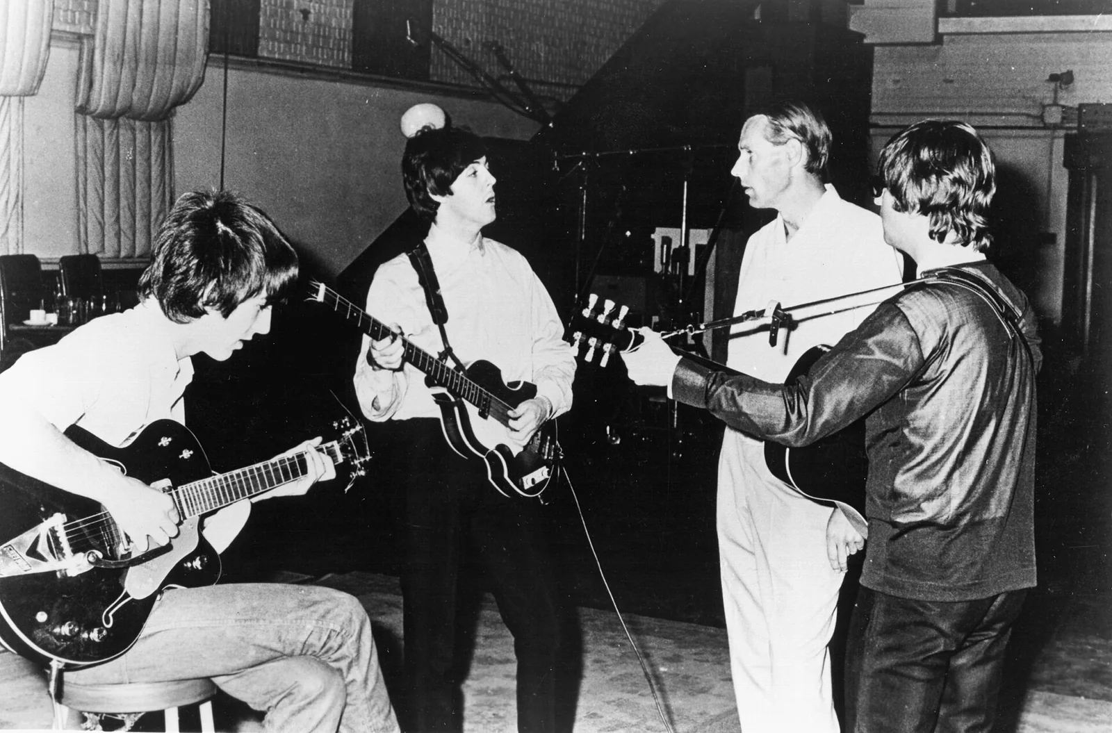 The Beatles with producer George Martin in a recording studio