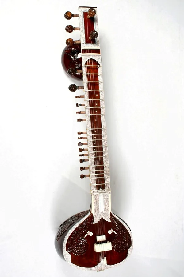 Close view of a sitar showing its strings, frets and decorated resonator